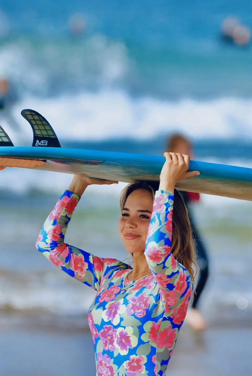 Surfer walking into the ocean with a board