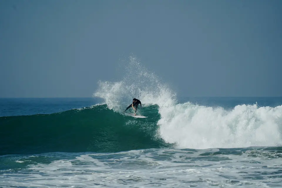 Aerial view of a surfer paddling in turquoise water
