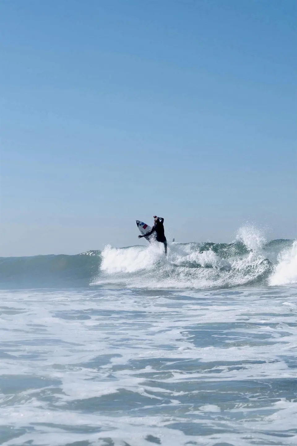 Surfer entering the water with a board