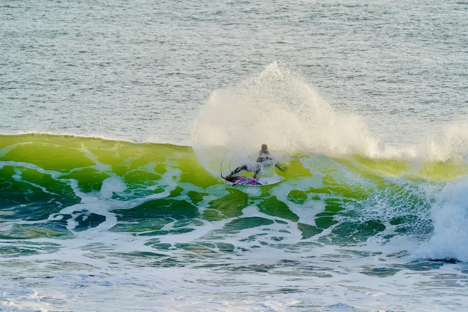 Surfer riding a blue wave in Taghazout